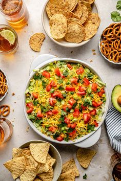 a bowl of mexican salad with tortilla chips and sliced avocado on the side