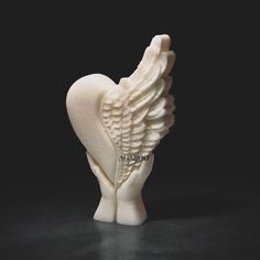 a white ceramic sculpture of an angel's wing