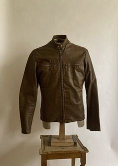 "1970s Harley Davidson cafe racer jacket with metal zipper cuffs and flannel lined chest pockets. Leather is in good condition and has been treated with Obenauf's leather oil which is made of natural oils suspended in a beeswax/propolis formula. Acetate lining is in excellent condition as well as the jacket which shows very little wear. Shoulders 17.75\" across Chest 40\" Waist 39\" Hem 40\" Length from back of neck to hem 25\" Sleeve length from shoulder seam to cuff 25\"" Harley Davidson Cafe Racer, Gold Evening Gown, Racer Leather Jacket, Cafe Racer Leather Jacket, Brown Cafe, Cafe Racer Jacket, Racer Jacket, Printed Shift Dress, Evening Gowns Formal