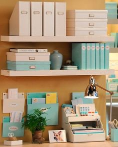 a desk with many boxes and binders on the shelves above it, along with other office supplies