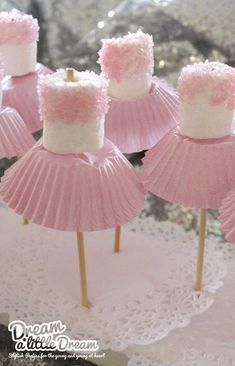 some pink cupcakes with white frosting on them