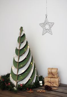 a christmas tree next to presents under a star ornament