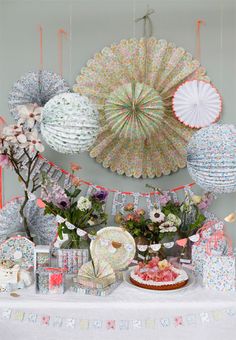 a table topped with lots of different types of paper fans and flowers on top of it