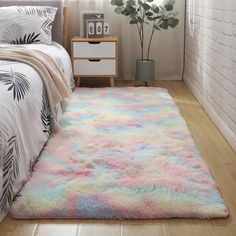 a bed room with a neatly made bed and a rug on the floor next to it