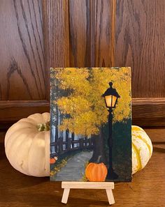 a painting of a fall scene with pumpkins and a lamp post