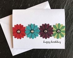 three colorful flowers on top of each other with the words happy birthday written below them