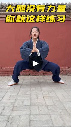 a woman doing yoga in front of a red wall