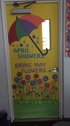 a door decorated with flowers, an umbrella and the words spring showers bring may flowers