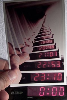 a person holding up an iphone photo with timers on it and the time displayed in black and white