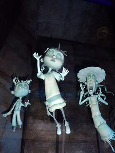 three cartoon figures are on display in a museum