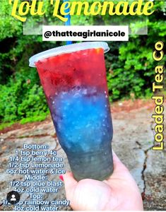 a hand holding up a drink with blue and red liquid in it