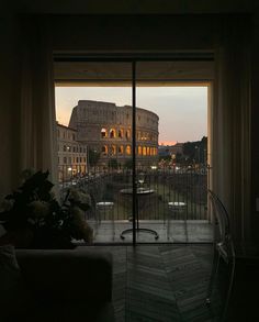 the view from inside an apartment looking out onto a roman colossion at sunset