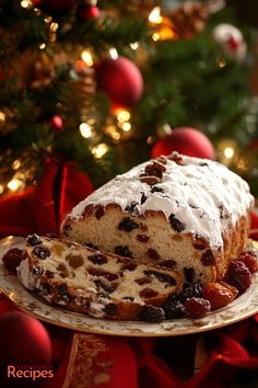 a cake with white frosting and cranberries on a plate next to a christmas tree