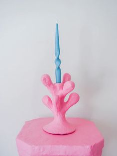 a pink cake with a blue candle on top