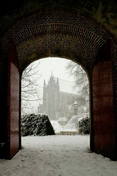 an archway leading to a castle in the snow