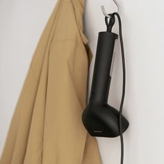 an electric hair dryer is hanging on the wall next to a coat hanger