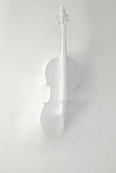 a white violin is hanging on the wall