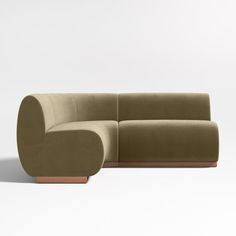 a couch that is sitting in the middle of a room with a white wall behind it