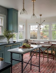 a kitchen with blue cabinets and brick flooring, along with a breakfast nook