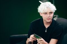 a young man with white hair holding a tablet