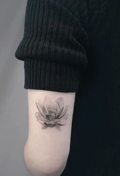 a woman's arm with a flower tattoo on the left side of her body