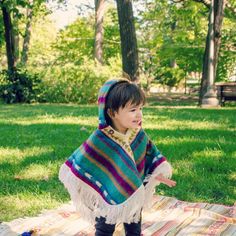 Poncho for baby in alpaca wool with hood and white fringe. Warm and comfy thanks to the softness of the alpaca wool. Comes with a hoodie, a small button at the collar and colorful stripes. Because of its ample fit and sleeveless design, it adapts to your growing child ! This collection of ponchos was woven by hand by the craftsmen of the Ecuadorian community of Otavalo. Their style is typical of the Andes region, where the poncho is part of the traditional clothes. Perfect for mid-season wear, a Poncho For Kids, Toddler Cape, Alpaca Wool Blanket, Baby Poncho, Kids Poncho, Alpaca Blanket, Boho Kids, Kids Scarf, Fall Clothing