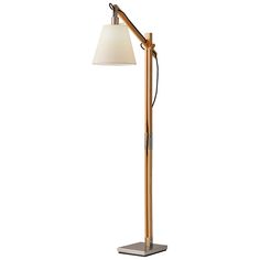 a floor lamp with a white shade on it's side and a metal base