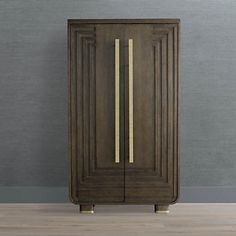 a tall wooden cabinet sitting on top of a hard wood floor next to a wall