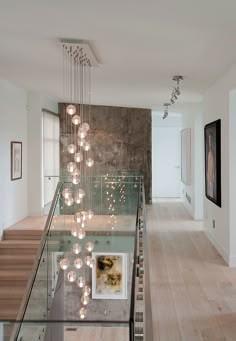 an image of a staircase with lights hanging from it's ceiling and stairs leading up to the second floor