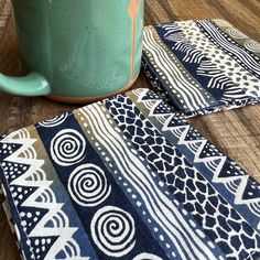 a blue mug sitting on top of a wooden table next to two placemats