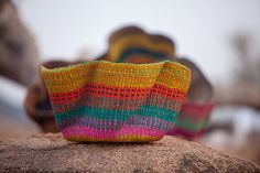 a colorful basket sitting on top of a rock