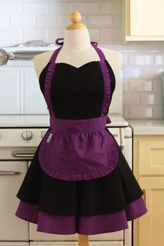 a mannequin wearing a purple and black apron