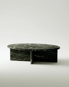 a black marble coffee table sitting on top of a white floor