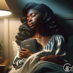 a woman sitting in bed reading a book next to a lamp on a night stand