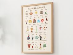 a framed poster with the words football alphabet written in english and spanish on white wall