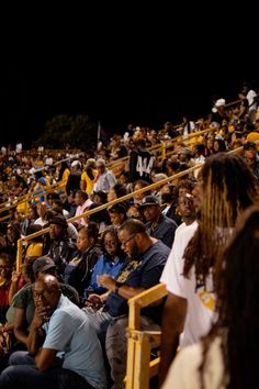 a group of people sitting in the stands at a baseball game