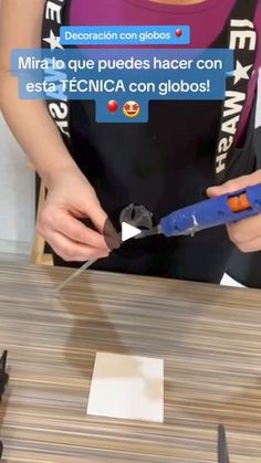 a woman cutting paper with scissors on top of a table