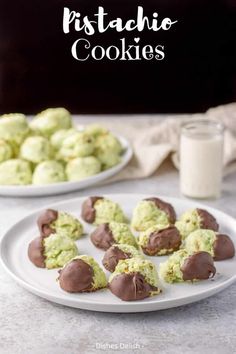 chocolate covered cookies on a white plate next to a glass of milk