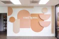 an office wall with the word cua home painted on it's side in white and pink