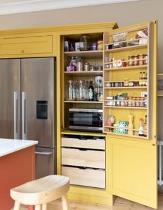 a kitchen with yellow cabinets and white counter tops