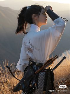 a woman dressed in traditional chinese clothing is looking into the distance with her hand on her head