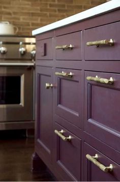 a kitchen with purple cabinets and stainless steel appliances