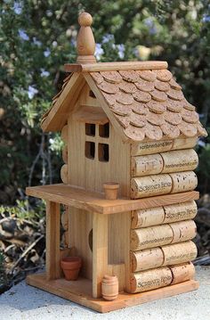 a wooden bird house made out of wine corks