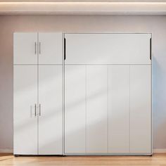 an empty room with two white cupboards and a chair on the floor in front of it