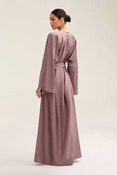 Indulge in luxury with the Batool Satin Maxi Dress. Its loose wide sleeves and lustrous satin fabric exude elegance, while the adjustable tie waist flatters your figure. Versatile design makes it perfect for Eid and beyond. Elevate your style with this exclusive piece. Model is 5'7 wearing size XS/58" Elegant V-neck Robe In Solid Color, Elegant Maxi Dress With Tie Waist And Kimono Sleeves, Elegant Wrap Robe With Tie Waist, Elegant Solid Color Long Sleeve Robe, Elegant Long Sleeve Solid Robe, Elegant Long Sleeve Robe, Elegant Long Sleeve Solid Color Robe, Elegant Robe With Tie Waist And Kimono Sleeves, Elegant Wrap Maxi Dress With Draped Sleeves