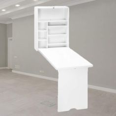 an empty room with a white shelf in the middle