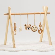 a wooden baby mobile with teddy bears hanging from it's sides