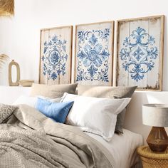 a bed with blue and white wall art above it