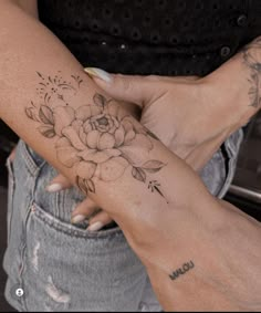 a woman's arm with a flower tattoo on it