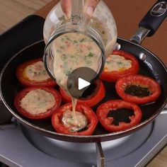 someone is pouring sauce on stuffed bell peppers in a skillet over an electric stove